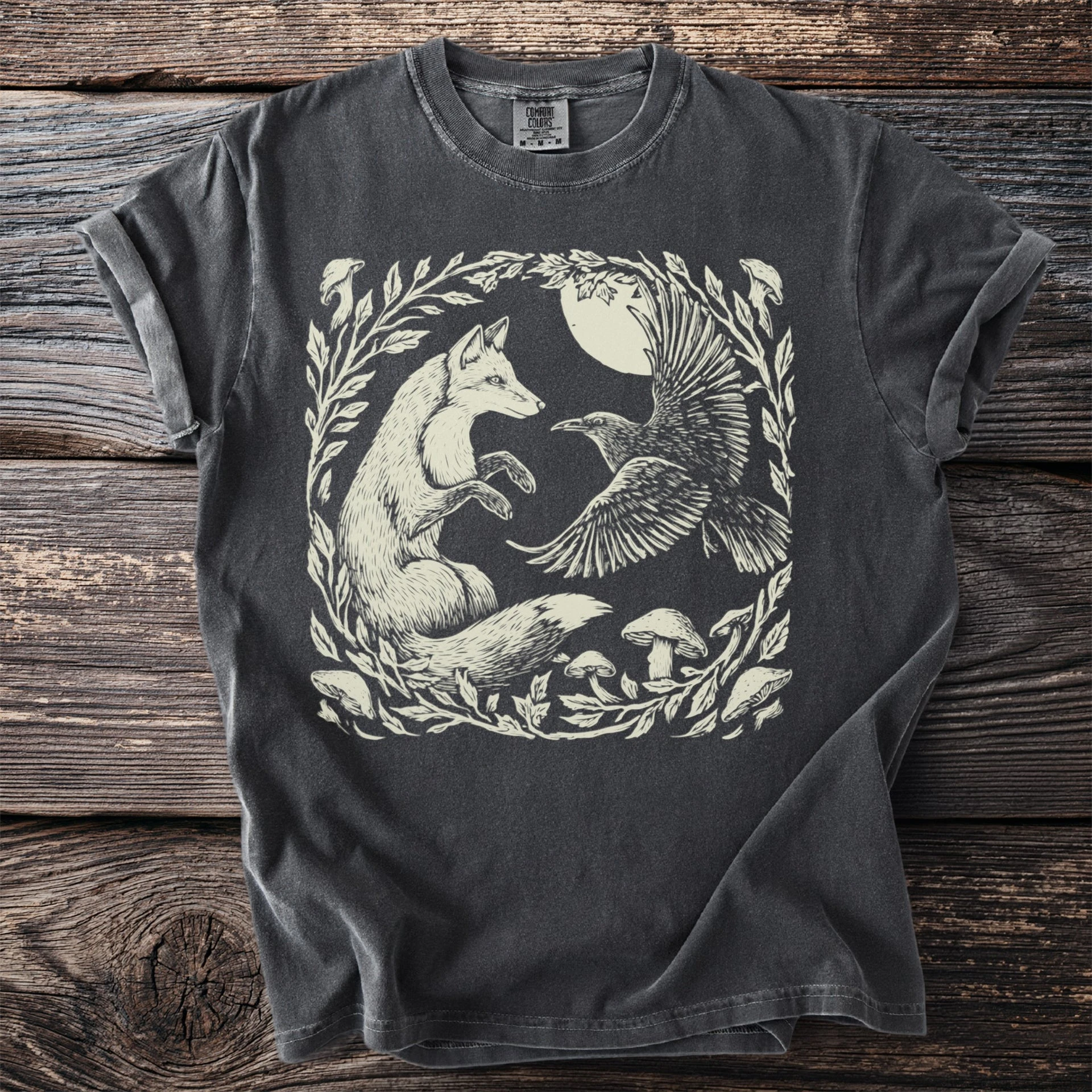 Fox and raven natural-history shirt artwork presented on a garment mockup